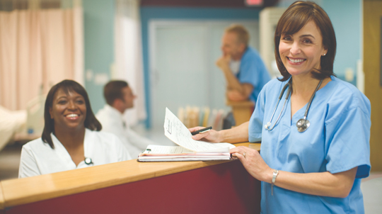 two healthcare providers smile at the camera